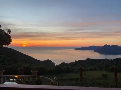 a view of the sun setting over a lake at Spacieuse villa avec vue exceptionnelle in Piana