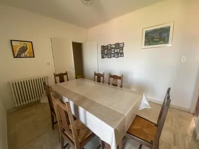 a dining room with a white table and chairs at Spacieuse villa avec vue exceptionnelle in Piana