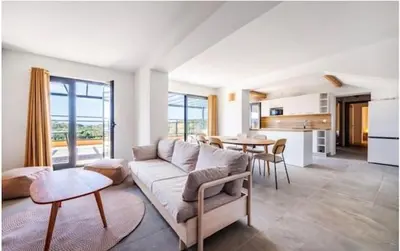 a living room with a couch and a table at Luxueux T4 de 100m2 avec roof top, piscine et plage in Pianottoli-Caldarello