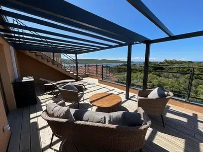 a deck with a table and chairs and a table and chairs at Luxueux T4 de 100m2 avec roof top, piscine et plage in Pianottoli-Caldarello