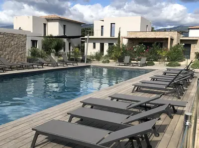 a swimming pool with lounge chairs next to a building at Appartement T3 L'Astragale - Classé 3 étoiles Tourisme in Lecci
