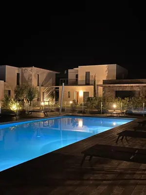 a swimming pool in front of a building at night at Appartement T3 L'Astragale - Classé 3 étoiles Tourisme in Lecci