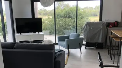 a living room with a couch and a flat screen tv at Appartement T3 L'Astragale - Classé 3 étoiles Tourisme in Lecci