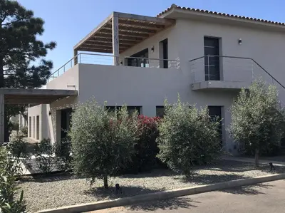 a white house with trees and bushes in front of it at Appartement T3 L'Astragale - Classé 3 étoiles Tourisme in Lecci