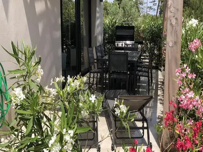 a patio with chairs and flowers on a porch at Appartement T3 L'Astragale - Classé 3 étoiles Tourisme in Lecci