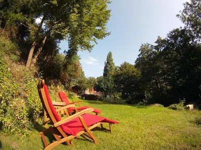 a group of chairs sitting in the grass at Holiday Apartment Segura 2 in Oletta