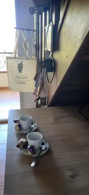 two cups of coffee sitting on a wooden table at Bienvenue à Sognu di Mare in Linguizzetta