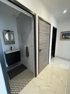 a bathroom with a shower and a sink and a door at Appartement 3 chambres in Propriano