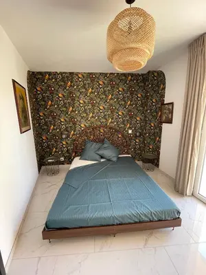 a bedroom with a bed with a wall covered in flowers at Appartement 3 chambres in Propriano