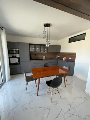 a kitchen with a wooden table and two chairs at Appartement 3 chambres in Propriano