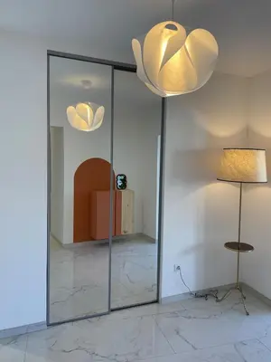 a room with a glass partition with a table and two lights at Appartement 3 chambres in Propriano