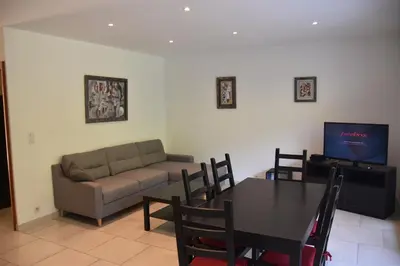 a living room with a table and a couch at Briloc Appartements Pietrosella à 50m de la plage in Pietrosella