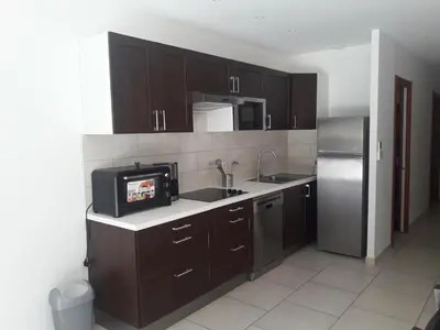 a kitchen with a sink and a refrigerator at Briloc Appartements Pietrosella à 50m de la plage in Pietrosella