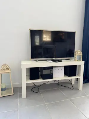 a white entertainment center with a large television on it at L'Ancrage - TV, Vue sur le port, Wi-Fi in Bonifacio