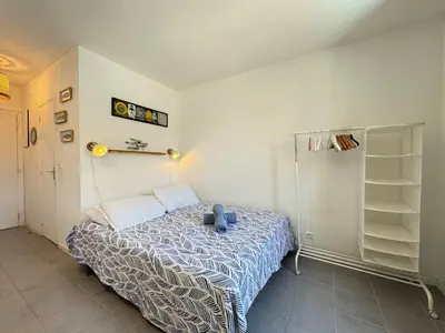 a bedroom with a bed with a blue teddy bear on it at L'Ancrage - TV, Vue sur le port, Wi-Fi in Bonifacio