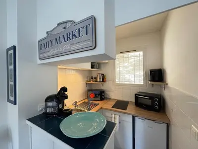 a kitchen with a sink and a sign on the wall at L'Ancrage - TV, Vue sur le port, Wi-Fi in Bonifacio