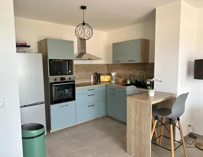 a kitchen with blue cabinets and a white refrigerator at Appartement 2-4 pers vue mer proche port in Porto-Vecchio