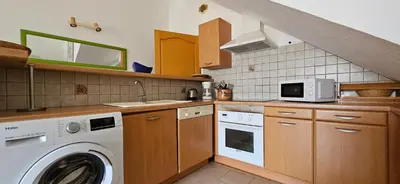a kitchen with a washing machine and a microwave at T1 Pinedda, Studio confort-Vue mer- Calme & soleil in Propriano