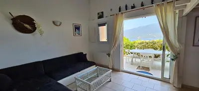 a living room with a couch and a large window at T1 Pinedda, Studio confort-Vue mer- Calme & soleil in Propriano