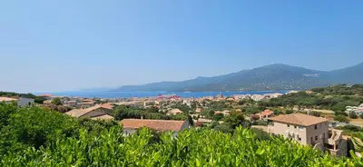 a town on a hill with the ocean in the background at T1 Pinedda, Studio confort-Vue mer- Calme & soleil in Propriano