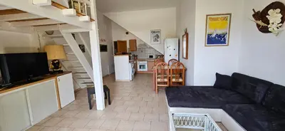 a living room with a couch and a kitchen at T1 Pinedda, Studio confort-Vue mer- Calme & soleil in Propriano