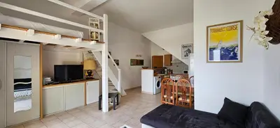 a living room with a couch and a kitchen at T1 Pinedda, Studio confort-Vue mer- Calme & soleil in Propriano