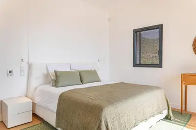 a white bedroom with a bed and a window at Villa Lume Di Palombaggia in Musoleu