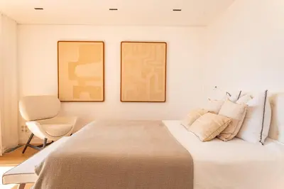 a bedroom with a bed with two pictures on the wall at Villa Lume Di Palombaggia in Musoleu