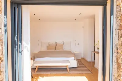 a bedroom with a white bed and a table at Villa Lume Di Palombaggia in Musoleu