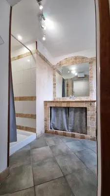 a bathroom with a tub and a sink and a mirror at Appartement Corte centre ville in Corte