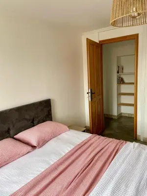 a bedroom with a bed with a pink pillow on it at Appartement Corte centre ville in Corte