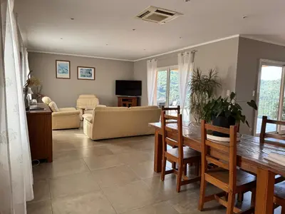 a living room with a table and a couch at Gîte Inseme, le calme entre mer et montagne en Corse in Arbellara