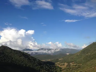 a view of a mountain valley with clouds in the sky at Gîte Inseme, le calme entre mer et montagne en Corse in Arbellara