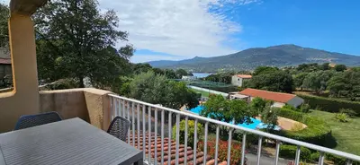 a balcony with a view of a pool and mountains at T2 Résidence Dolce & Vita B4 vue mer et piscine in Propriano