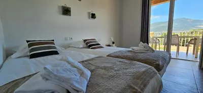 two beds in a room with a view of a balcony at T2 Résidence Dolce & Vita B4 vue mer et piscine in Propriano