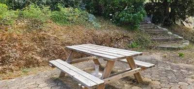 a wooden picnic table sitting next to some stairs at T2 Résidence Dolce & Vita B4 vue mer et piscine in Propriano