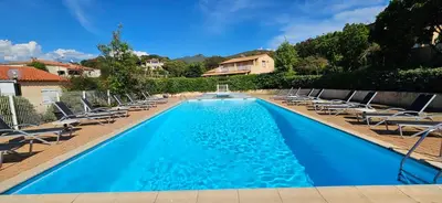 a swimming pool with lounge chairs and a house at T2 Résidence Dolce & Vita B4 vue mer et piscine in Propriano