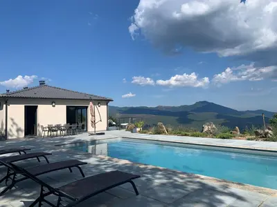 a swimming pool with two chairs next to a house at Villa H in Casanova