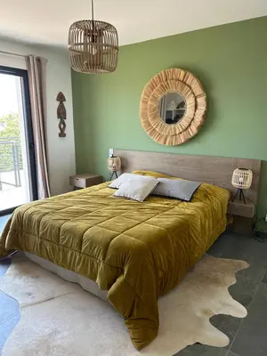 a bedroom with a large bed and a mirror at Villa H in Casanova