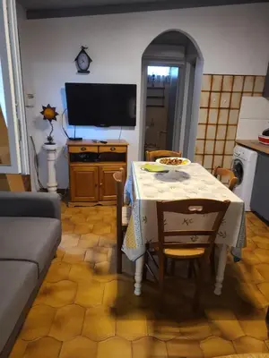 a living room with a table and a television at Casinu - Casino in San-Nicolao