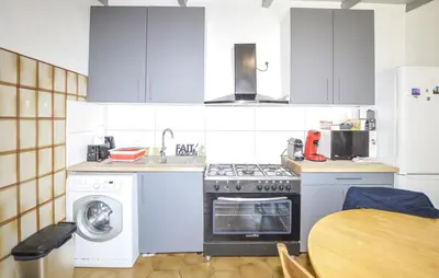 a kitchen with a stove and a washing machine at Casinu - Casino in San-Nicolao