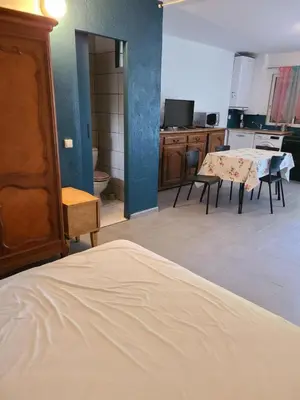 a room with a kitchen with a table and chairs at Casinu - Casino in San-Nicolao