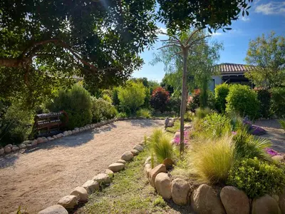 a garden with a bench and some bushes and trees at Villa Maestro Maria Charme Confort et Accueil Chaleureux à 5 min de la plage in Lecci