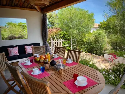 a wooden table with food on top of a patio at Villa Maestro Maria Charme Confort et Accueil Chaleureux à 5 min de la plage in Lecci