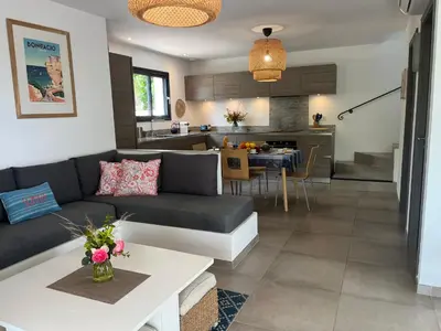 a living room and kitchen with a couch and a table at Villa Maestro Maria Charme Confort et Accueil Chaleureux à 5 min de la plage in Lecci