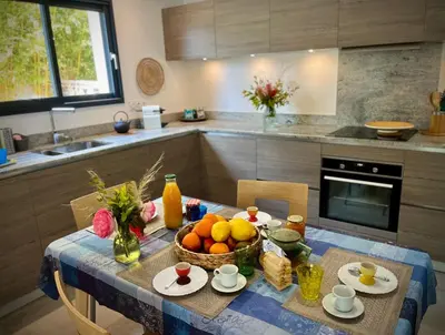 a kitchen with a table with a bowl of fruit on it at Villa Maestro Maria Charme Confort et Accueil Chaleureux à 5 min de la plage in Lecci