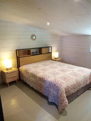 a bedroom with a large bed and two night stands at La Ferme Du Maquis in Antisanti
