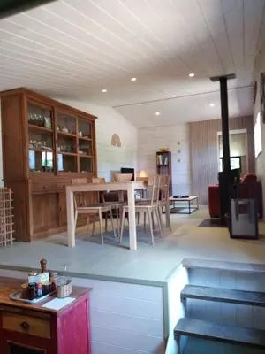 a living room with a table and a dining room at La Ferme Du Maquis in Antisanti