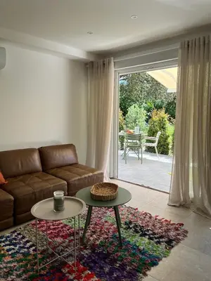 a living room with a couch and a table at Rez-de-villa avec terrasse privative sur jardin in Ajaccio