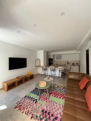 a living room with a couch and a table at Rez-de-villa avec terrasse privative sur jardin in Ajaccio